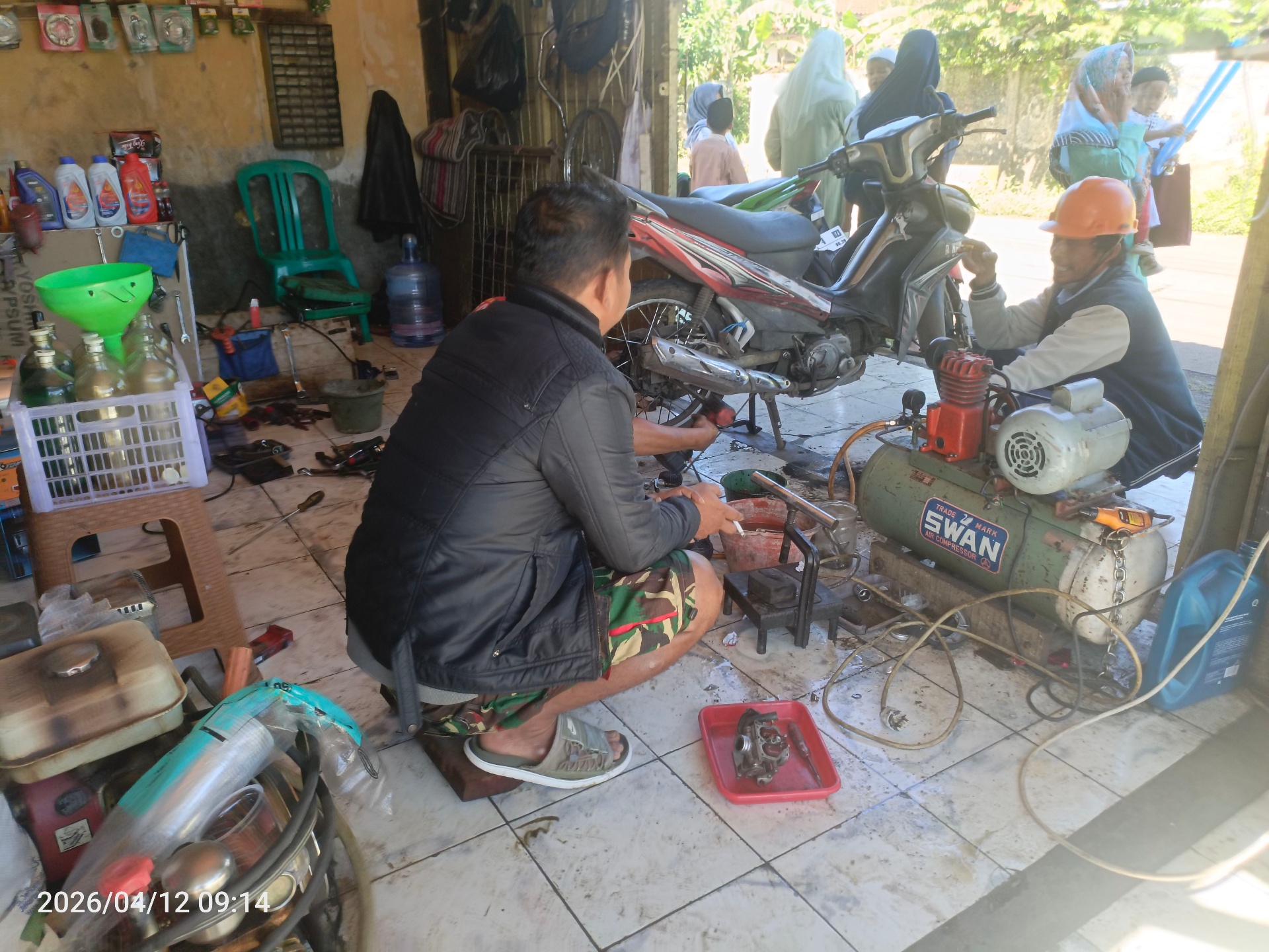 Aktivitas servis motor dengan kompresor aktif di workshop